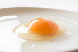たまごを割って皿に乗せている