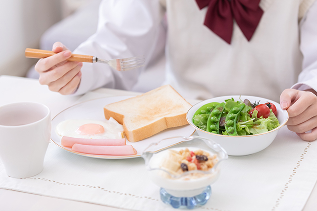 朝食を食べる中学生